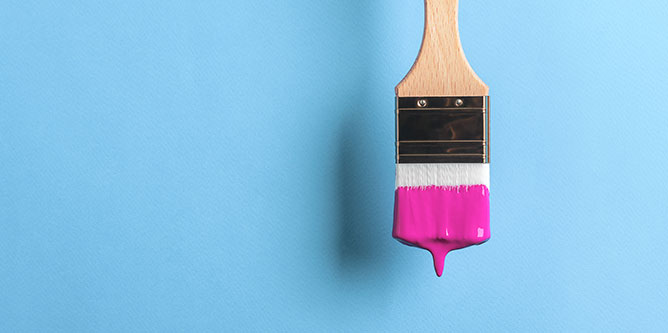 pink paint on paintbrush on blue background