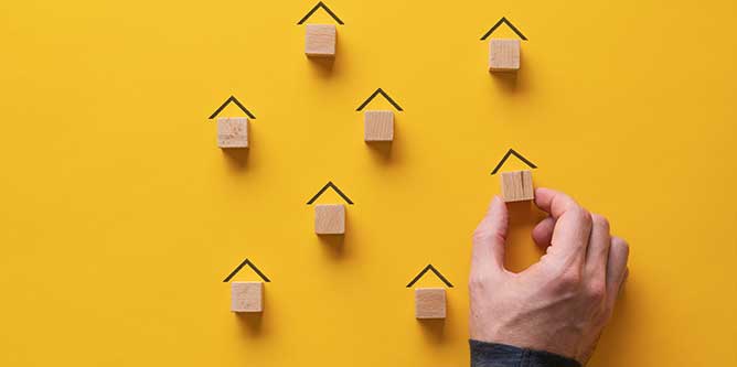 Miniature houses on yellow background