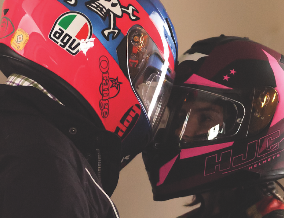 man and woman in motorbike helmets looking at each other photographed by rolf and co